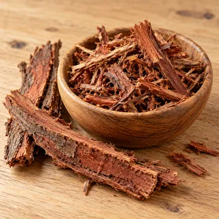 Reddish-brown catuaba bark pieces and shavings in a wooden bowl
